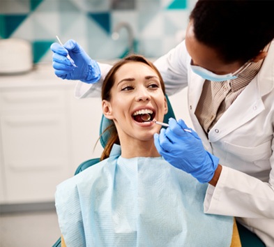 Woman in dentist’s chair undergoing treatment (Delta Dental Premier Coverage Availability & Fees 