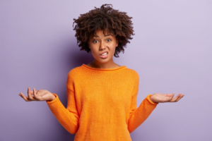 Young woman shrugging with questioning expression