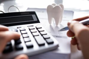 Man using calculator to budget for dental care